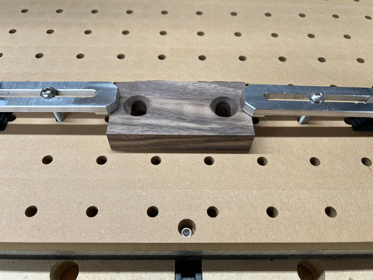 two strap clamps holding a block of wood on a cnc router fixture plate